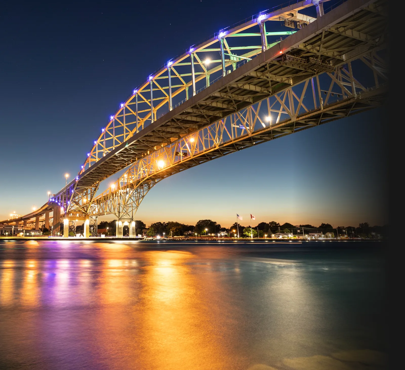 The Blue Water Bridge lit up over the St. Clair River at dusk